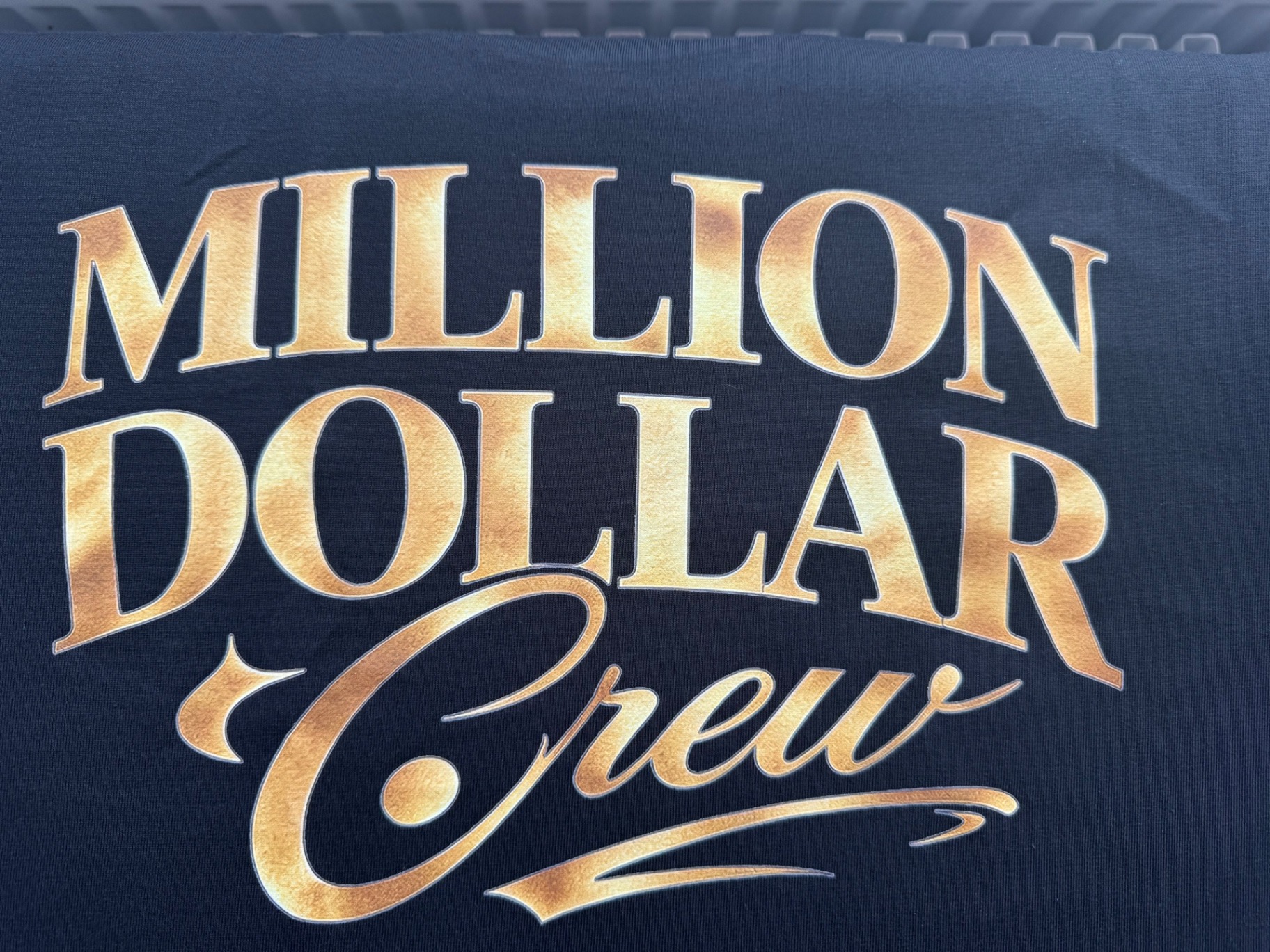Close-up of the large gold Million Dollar Crew back print