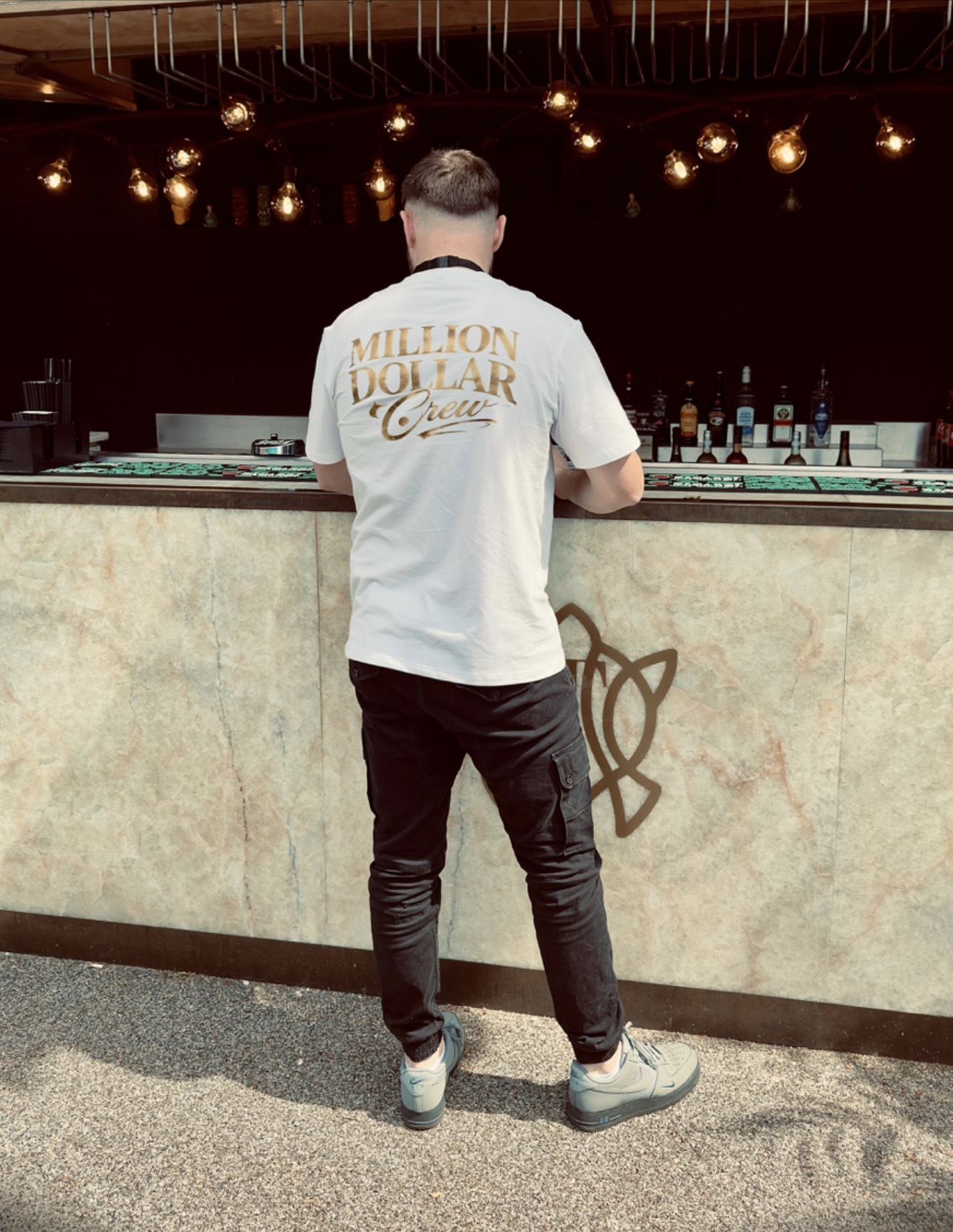 Back view of the white Million Dollar Crew t-shirt with large gold back print